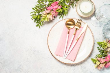 Masa ayarları beyaz tabak, çatal bıçak ve çiçeklerle.