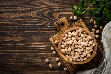 Ahşap mutfak masasında, beyaz kasede nohut..