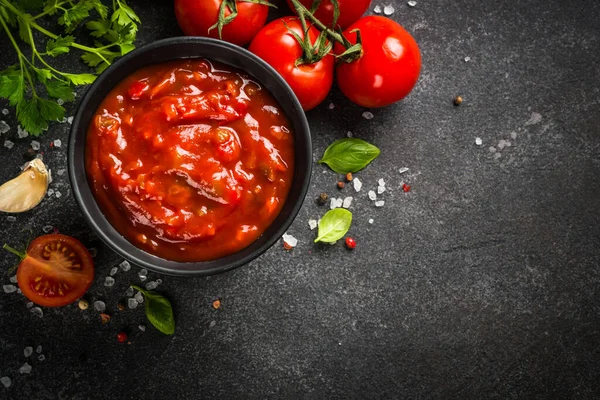 Tomatsås i en skål med kryddor och färska tomater. — Stockfoto