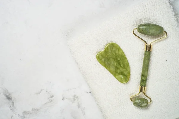 Jade rodillo y gua sha masajeador de piedra para la cara. — Foto de Stock