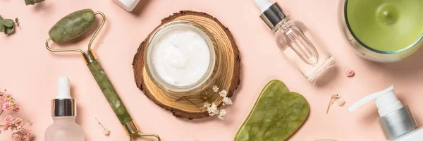 Produtos cosméticos - Jade rolo e água sha massageador com creme e garrafas de soro em fundo pastel. — Fotografia de Stock