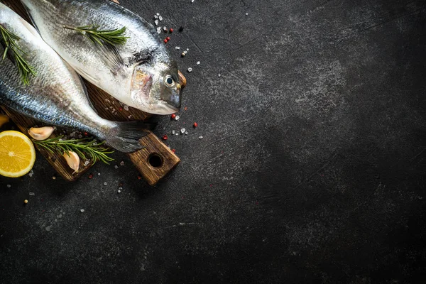 Dorado de pescado fresco sobre mesa de piedra negra. —  Fotos de Stock