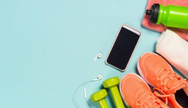 Mavi arkaplan görünümünde spor aletleri.