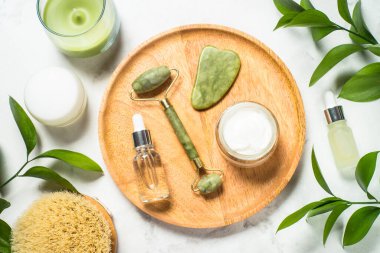 Spa ürünü. Yüz kremi ve serum şişeli Jade roller ve gua sha..