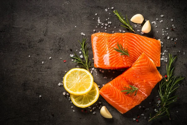 Lax fisk med ingredienser vid svart bord. — Stockfoto