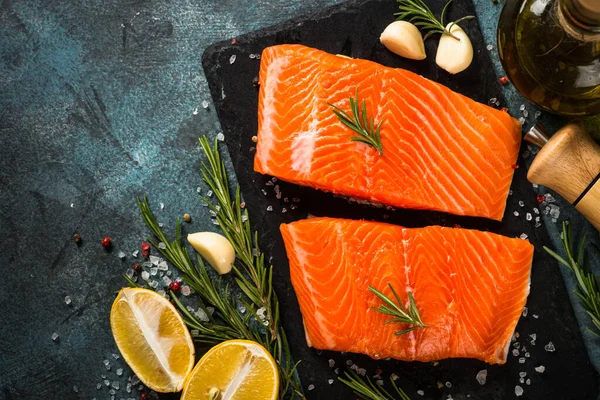 Ikan salmon dengan bahan-bahan di meja hitam. — Stok Foto