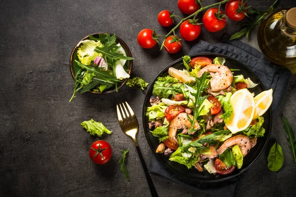 Салат з морепродуктів за чорним столом . — стокове фото