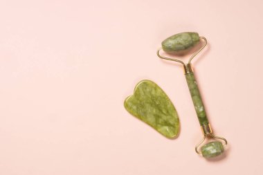 Yeşim silindir ve gua sha taş masajcı üst görünüm.