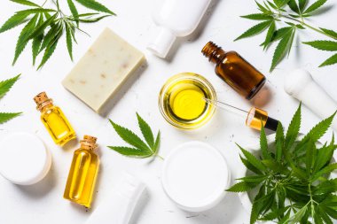 Kenevir yağı, krema, sabun ve beyaz yapraklar.