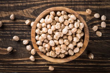 Ahşap mutfak masasında, beyaz kasede nohut..