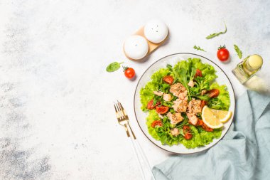 Beyaz masada fırında balık ve yeşil salata..