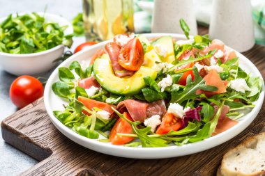 Yeşil yapraklı taze salata, jamon ve domates..