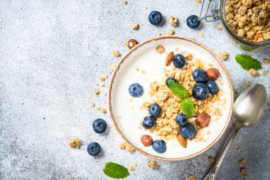 Taş masada taze yaban mersinli yoğurt taneleri..