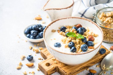 Taş masada taze yaban mersinli yoğurt taneleri..