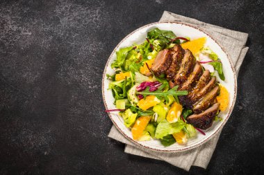 Fırında ördek, yeşil salata ve portakallı salata..
