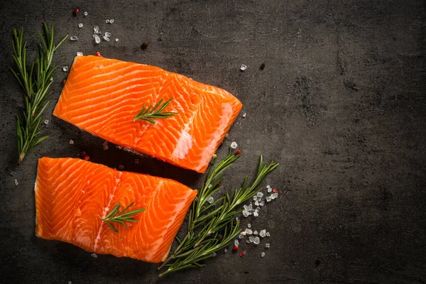 Pesce salmone con ingredienti a tavola nera. — Foto Stock