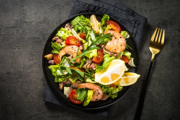 Seafood salad at black table. — Stock Photo, Image