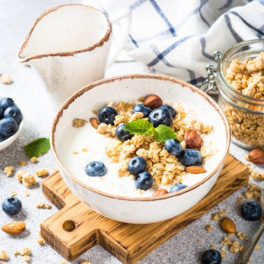 Taş masada taze yaban mersinli yoğurt taneleri..