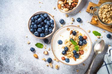 Taş masada taze yaban mersinli yoğurt taneleri..