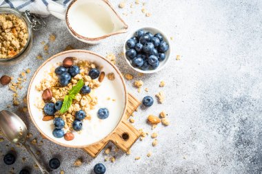 Taş masada taze yaban mersinli yoğurt taneleri..