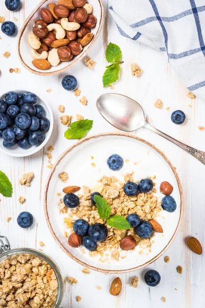 Granola yogurt dengan blueberry segar di atas meja kayu putih. — Stok Foto