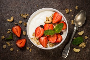 Mısır gevrekli yoğurt ve beyaz kasede çilek.