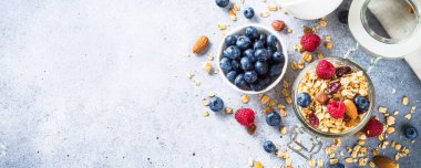 Cam kavanozda taze böğürtlenli granola.