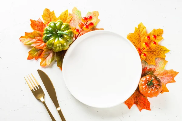 Ajuste de mesa de otoño con plato blanco, cubiertos de oro y decoraciones de otoño. — Foto de Stock