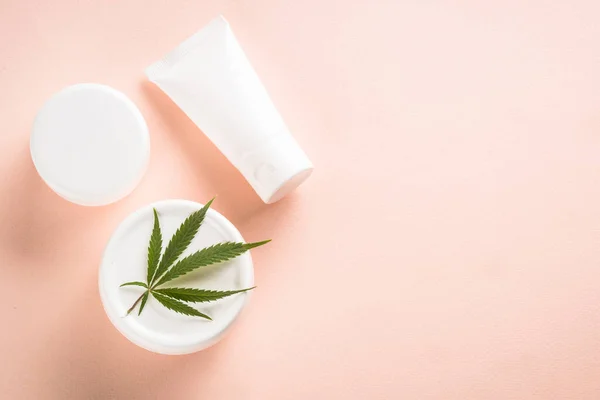 Cannabis-Kosmetikprodukte auf rosa Hintergrund von oben. — Stockfoto