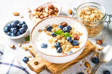 Taş masada taze yaban mersinli yoğurt taneleri..