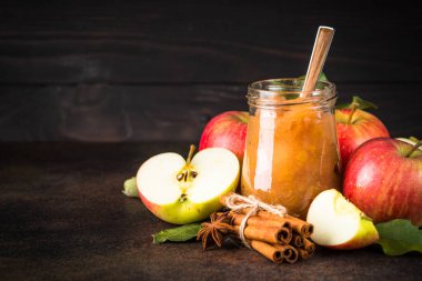 Baharatlı elma reçeli ve koyu arkaplanda taze elma.