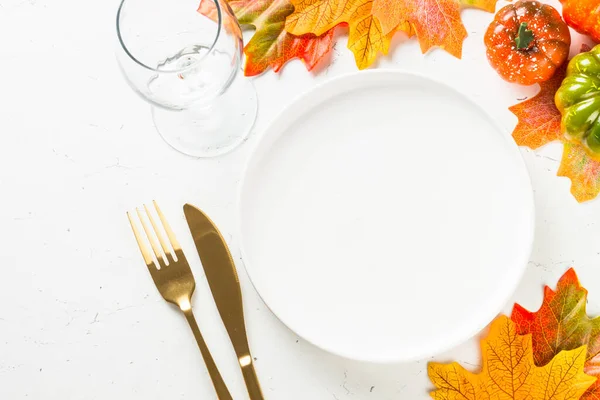 Ajuste de mesa de otoño con plato blanco, cubiertos de oro y decoraciones de otoño. — Foto de Stock