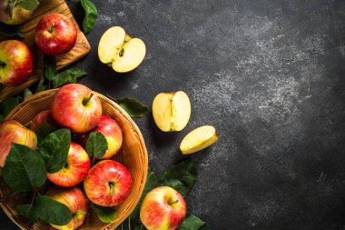Beyaz masadaki sepetin içinde taze kırmızı elmalar.