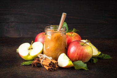 Baharatlı elma reçeli ve koyu arkaplanda taze elma.