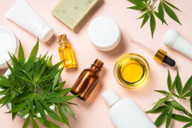 Kenevir yağı, krema, sabun ve beyaz yapraklar.