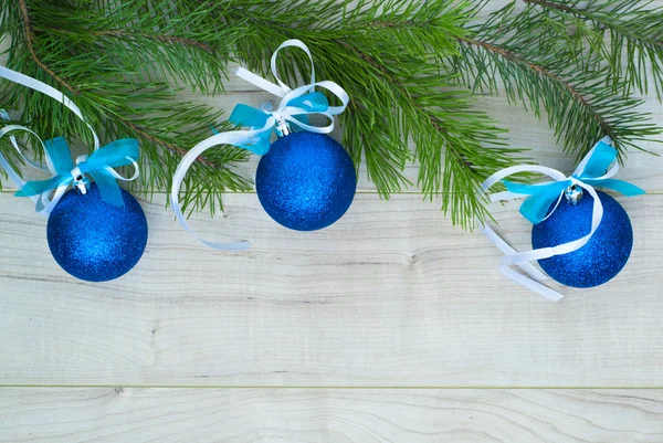 Blaue Kugeln mit Bändern und Weihnachtsbaumzweig — Stockfoto