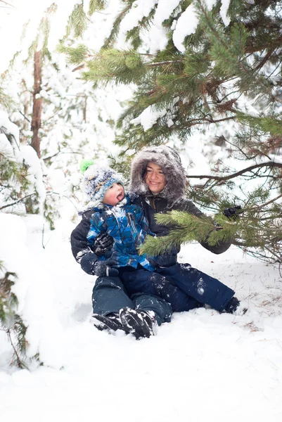 Matka a dítě chlapec hraje v zasněžené zimní venkovní — Stock fotografie