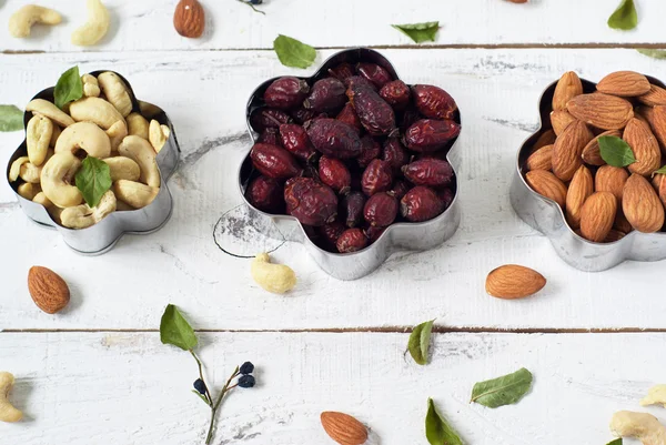 Almonds, cashews,  wild rose in a cookie cutters — Stock Photo, Image