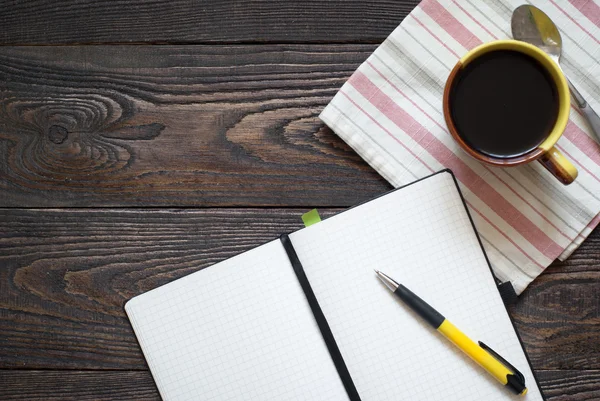 Notebook, pen en koffie pot op tafel — Stockfoto