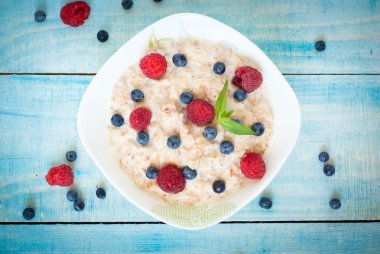 Oatmeal with different berries clipart