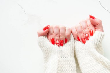 Noel manikürlü güzel eller, tatil resimli kırmızı tırnaklar. Tasarım için alanı olan üst görünüm.