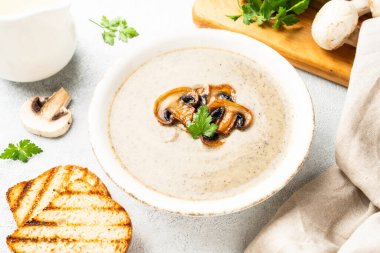 Beyaz mutfak masasında mantar çorbası püresi. Sağlıklı vejetaryen yemekleri. Kapat..