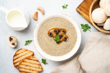 Beyaz mutfak masasında mantar çorbası püresi. Sağlıklı vejetaryen yemeği. Dizayn için alanı olan düz uzandı.