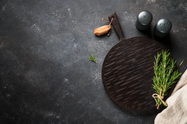 Mutfak masasında yemek arkaplanı. Baharatlar, otlar ve kesme tahtası. Metin için boşluk ile düz uzandı.