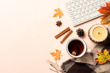 Laptop, cup of tea, spices and scarf with fallen leaves. Flat lay image with space for text.