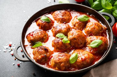 Domates soslu köfte ve fesleğen. Geleneksel İtalyan yemekleri. Resmi kapat.
