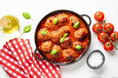 Beyaz arka planda siyah tabakta köfteler. Düz görünüm.