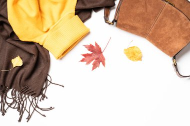 Sonbahar kumaşı ve aksesuarları beyaz arka planda fotokopi alanı ile. Atkı, kazak ve yapraklı çanta..