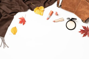 Sıcak sonbahar kompozisyonu. Sonbahar kumaşı ve aksesuarları beyaz arka planda düşmüş yapraklarla. Dizayn için alanı olan düz uzandı.