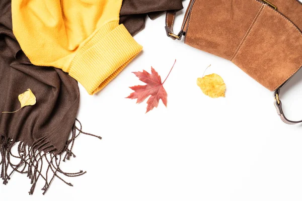 Sonbahar kumaşı ve aksesuarları beyaz arka planda fotokopi alanı ile. Atkı, kazak ve yapraklı çanta..